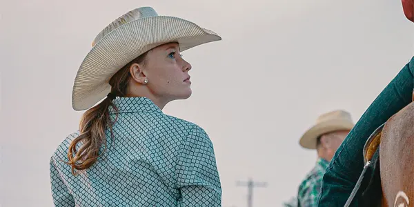 cowgirl next to rider on horse