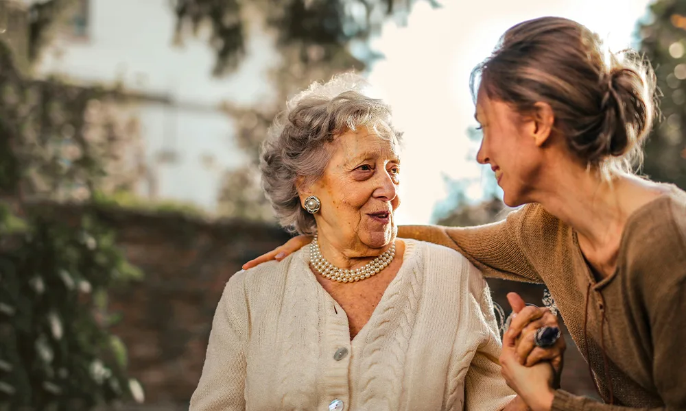 younger woman holding older woman's hand