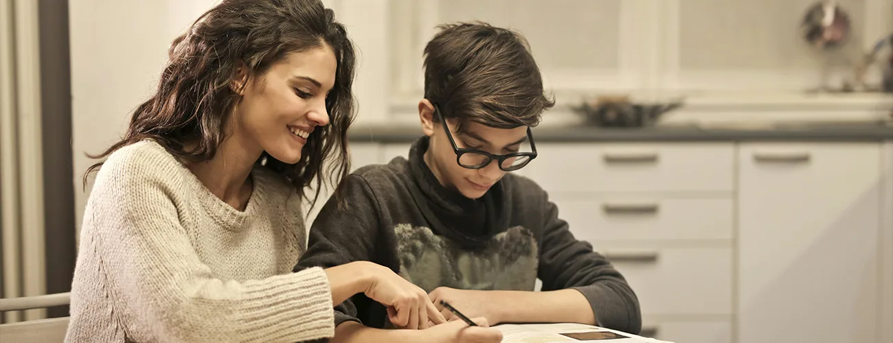 woman helping son with work on table
